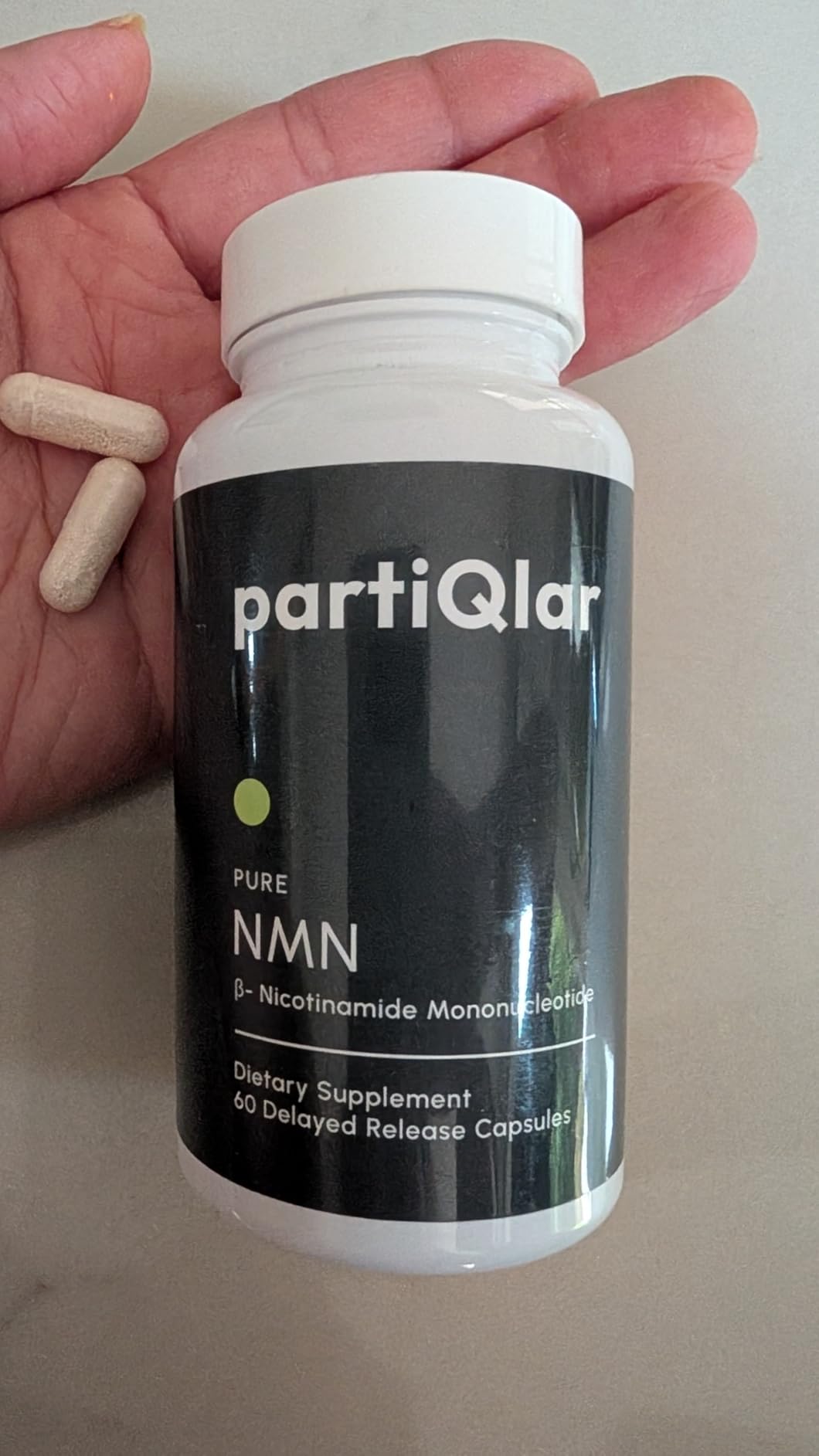 Customer holding partiQlar Pure NMN with two capsules