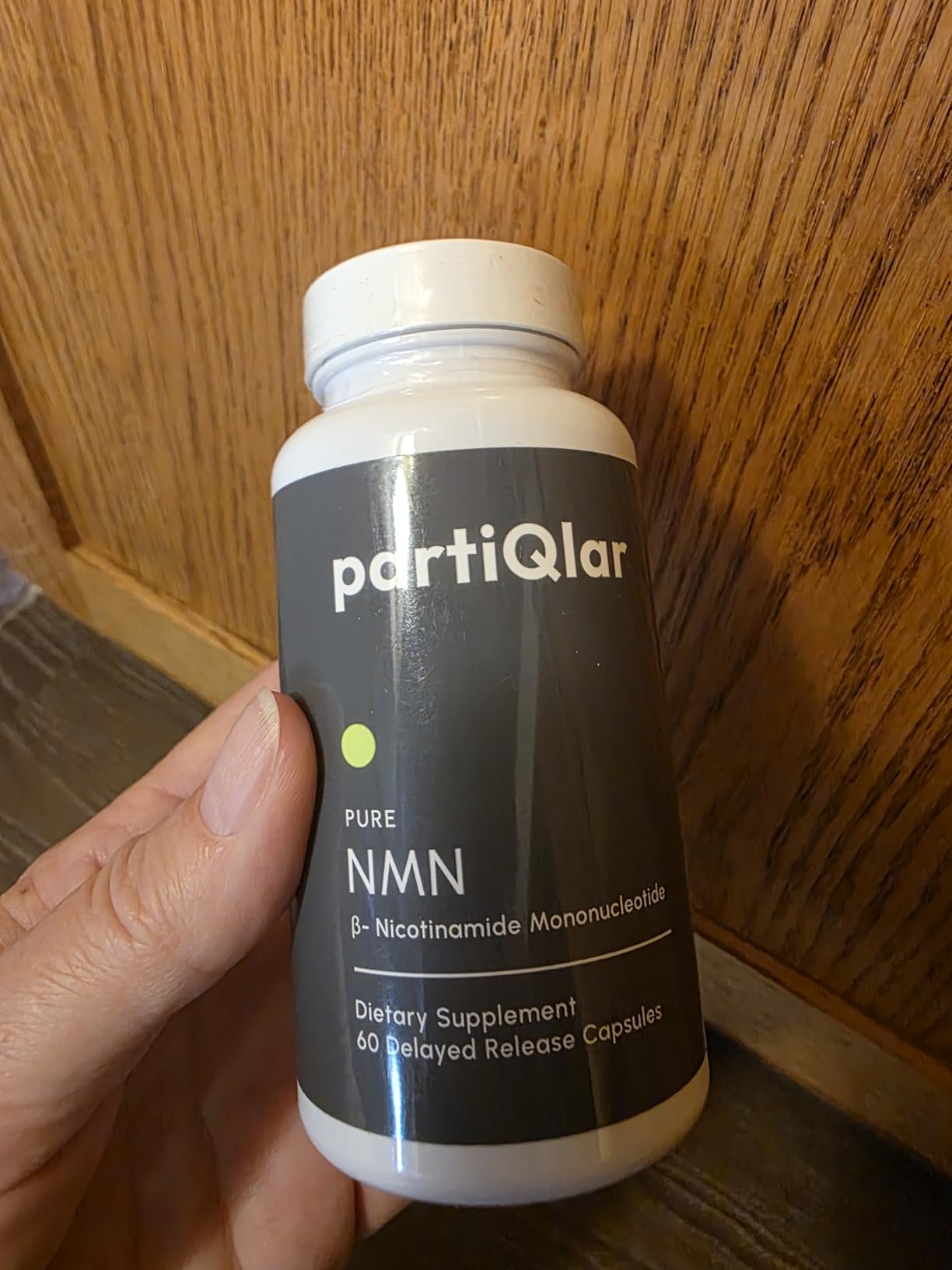 Customer holding a bottle of partiQlar Pure NMN